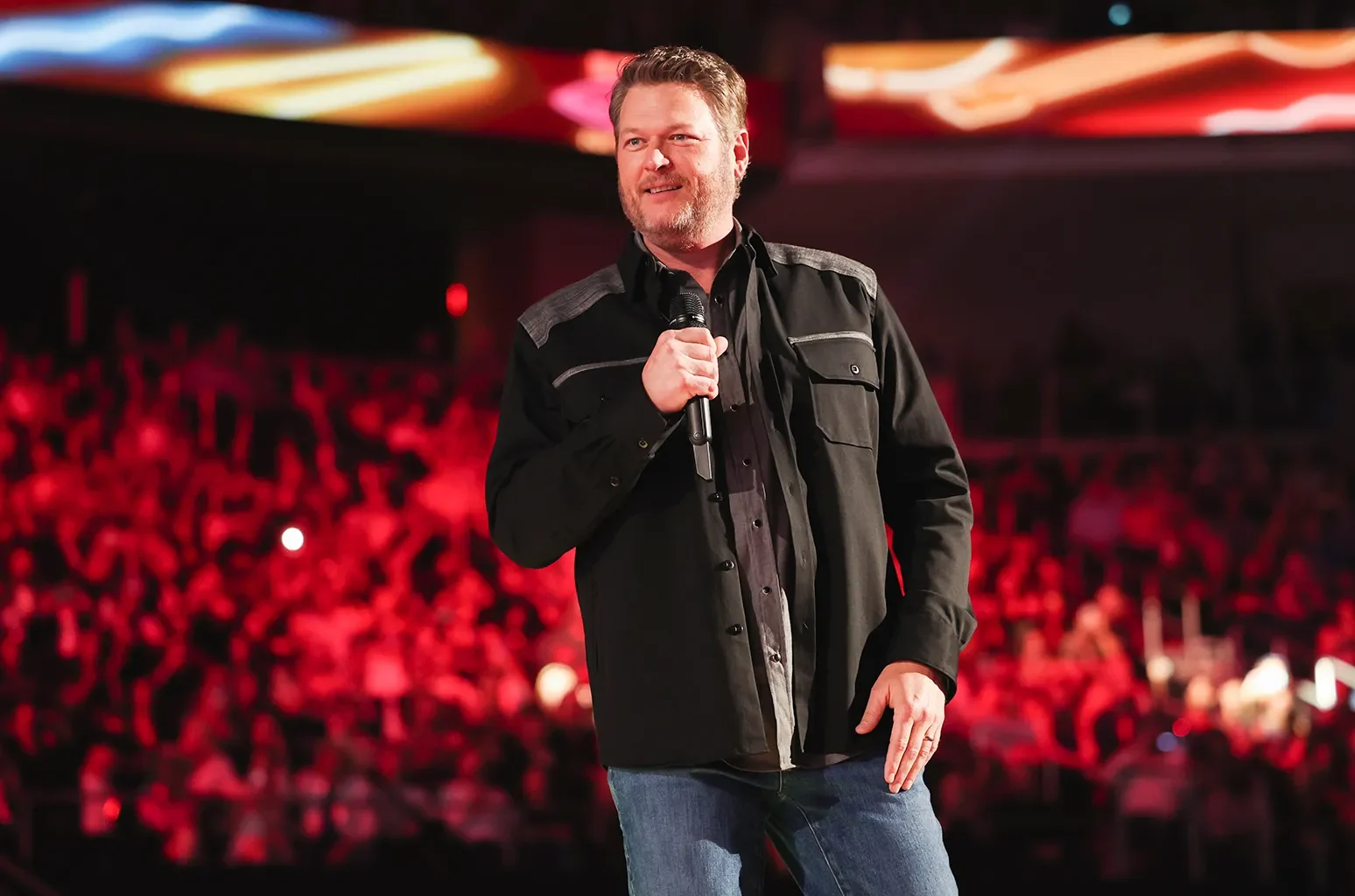 Singer in front of red arena crowd